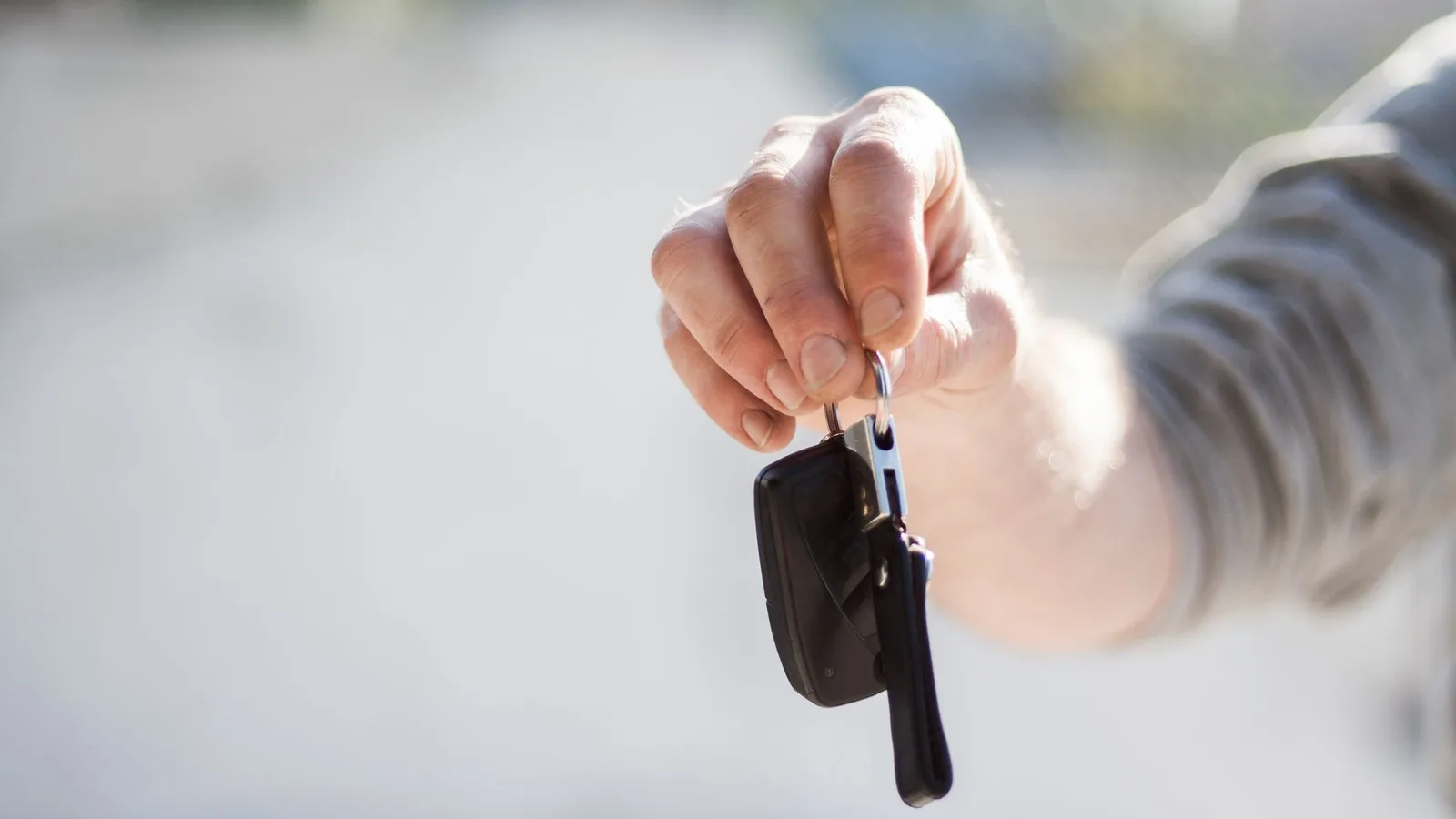 Hand holding out a set of car keys