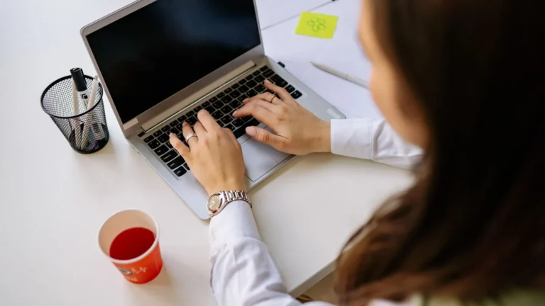 Person practising theory test questions on a laptop at a desk